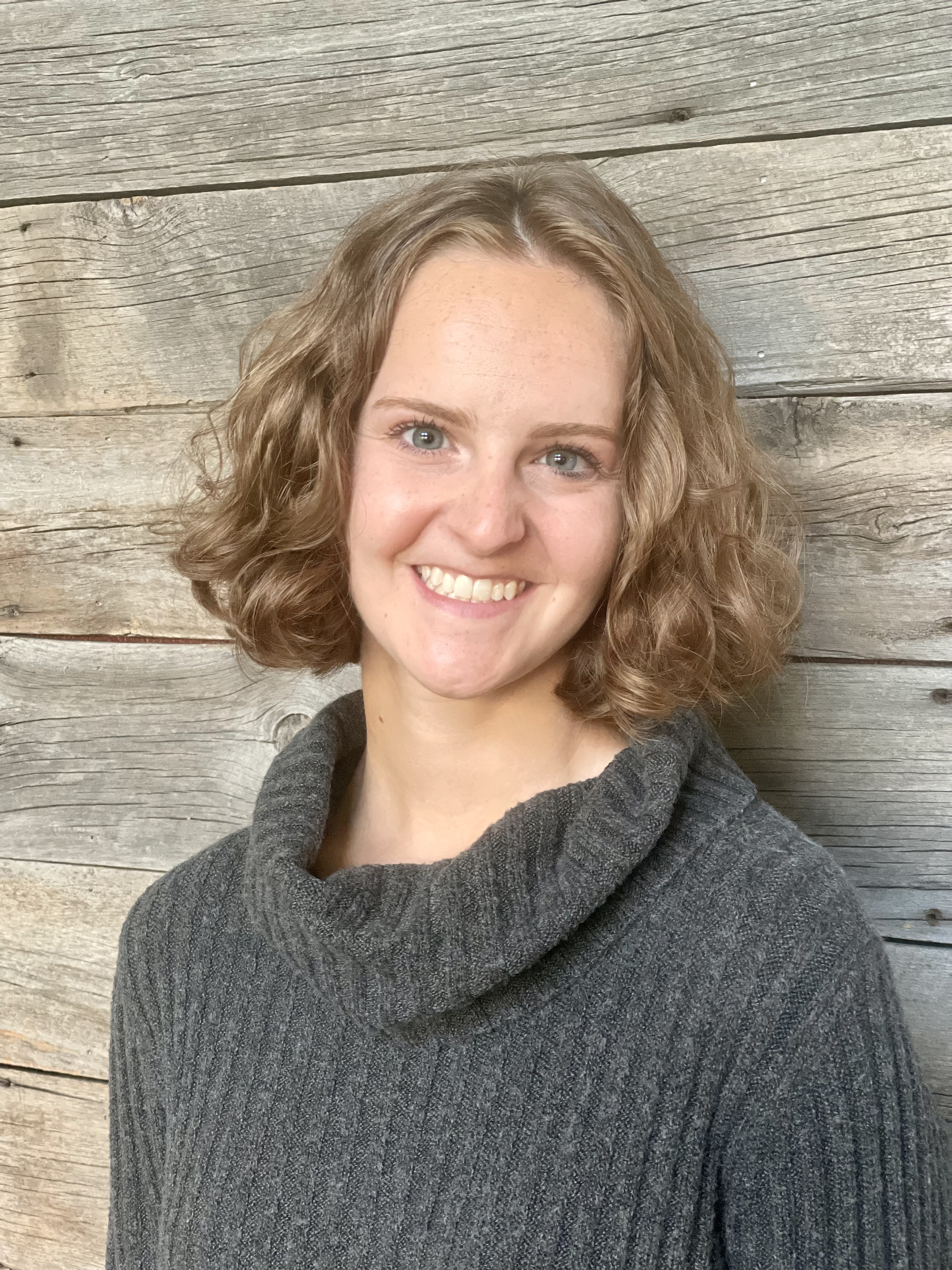 headshot photograph of the author, Grace, smiling at the camera