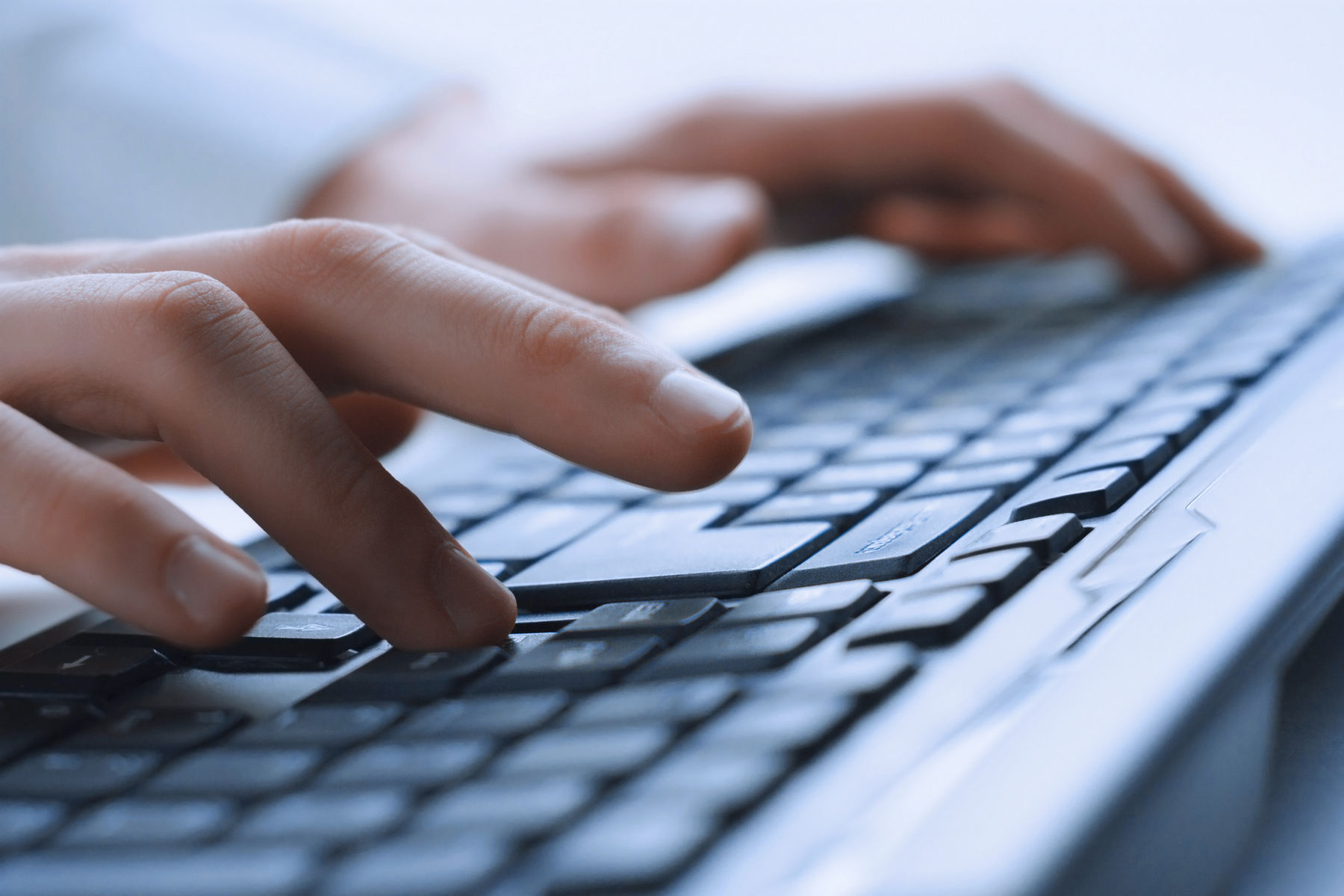 Closeup of fingers typing on a keyboard.