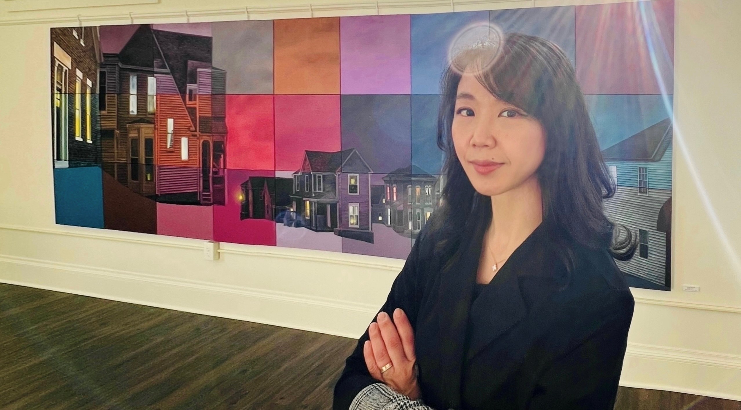 woman in gallery standing in front of her painting