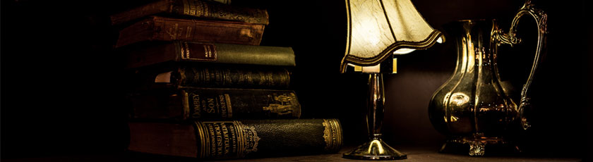 dark photo with lamp lit up , books and a pitcher