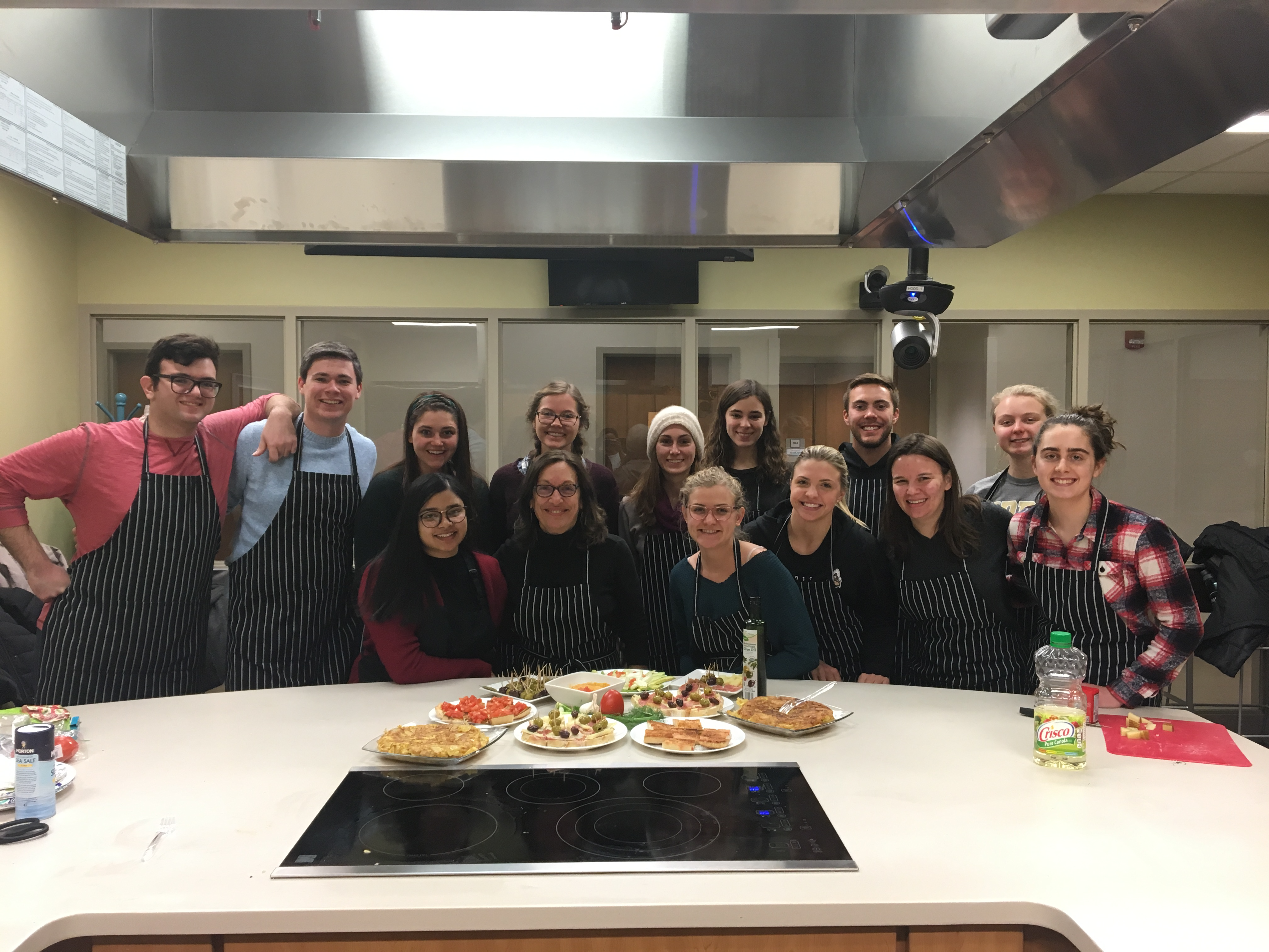 Group of Students Posing Together in a Teaching Kitchen with Prepared Dishes on the Counter