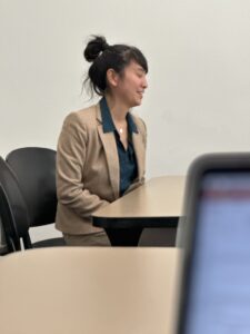 Vanessa Sheu seated at a table, giving her dissertation defense