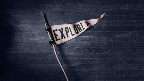a triangular flag tied to a branch that says explore
