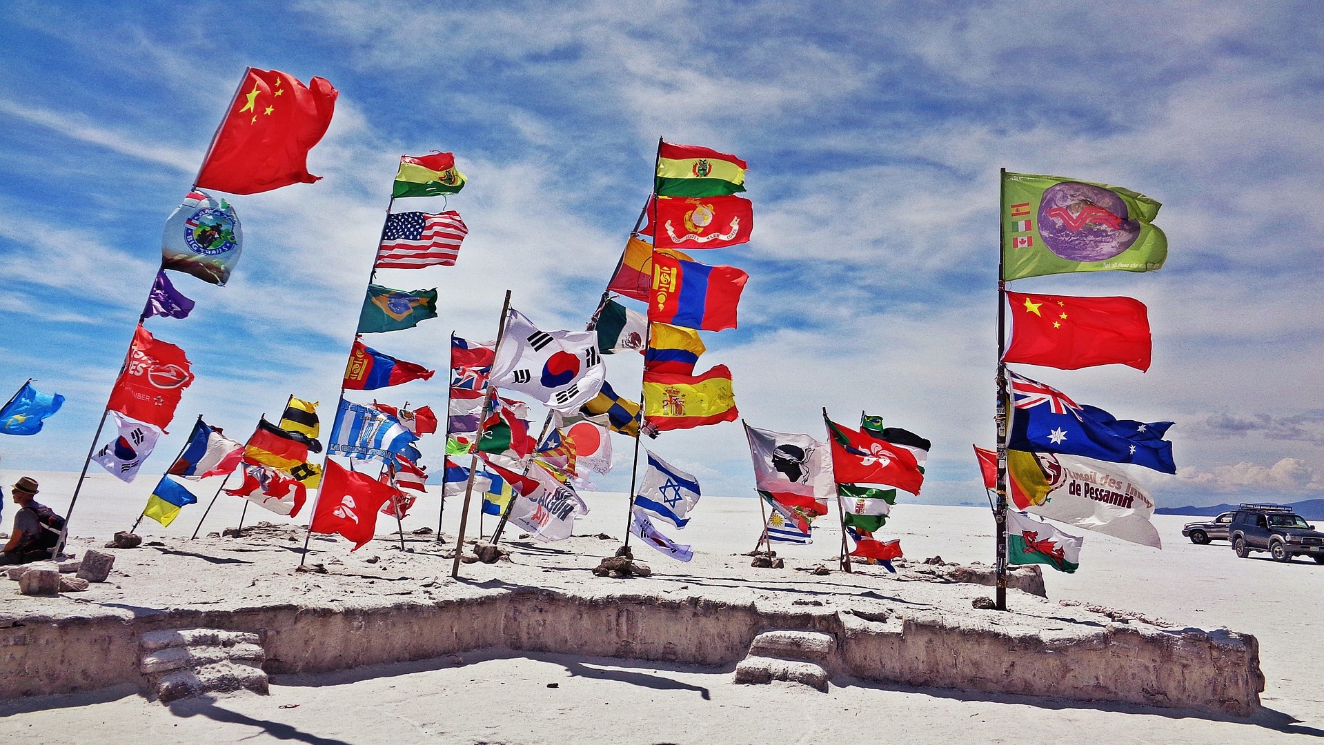 standing poles with dozens of international flags at a remote destination