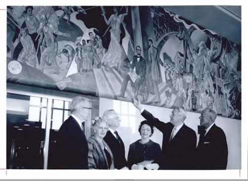 Dedication of the Spirit of the Land Grant College, October 2, 1962. Shown in front of the painting in the memorial center prior to the ceremony are, left to right: Eugene Savage, Mrs. and Mr. Walter Scholer, Mrs. and Dr. R.B. Stewart, and President Fredrick Hovde. The Scholers and Stewarts donated the mural to the University. Image courtesy of Purdue University Archives. All rights reserved.