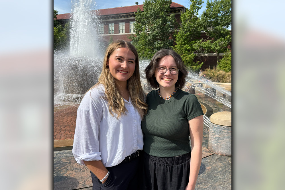 Madison Succaw and Allie Beene smiling side-by-side in front of the Loeb Fountain.