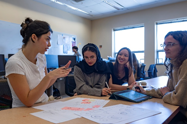 Four students talking about a group project they are working on